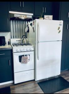 a kitchen with a white refrigerator and a stove at 1 BR Cozy Apartment with Fire Pit Short walk to town in Nappanee