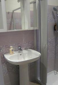 a bathroom with a white sink and a shower at Verde Mare in Trapani