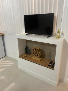 a white shelf with a tv on top of it at La petite racine in Sainte-Marie