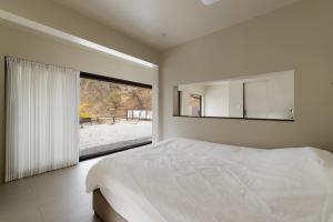 a bedroom with a bed with a mirror and a window at 양평스테이 Private Stay Near Seoul - Entire House Just for You 