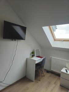 a room with a desk and a tv on the wall at Diamentowa 7 Rent Home Konarzewo Poznań in Poznań