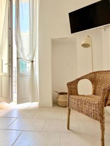 sala de estar con silla de mimbre y ventana en Perla di Mola, en Mola di Bari
