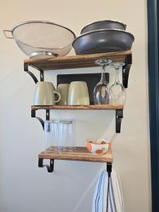 a shelf with pots and pans and glasses on it at Le Parisien in Le Mans +6 photos