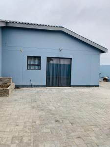 a blue building with a window and a patio at The Columbine Couples Suite in Swakopmund +3 photos