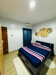 a bedroom with a bed with a blue comforter at Ilé Ifè in Cotonou +22 photos