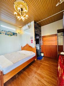 a bedroom with a bed and a chandelier at Nhà Nghỉ Đại Lý Bình Châu in Xuyên Mộc