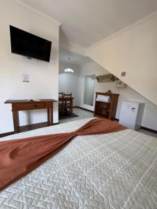 a bedroom with a large bed with a flat screen tv on the wall at Pousada Banzay in Paraty