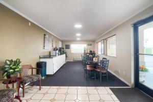 a living room with a table and chairs and a kitchen at Deerfield Inn By Capital O Blytheville AR I55 in Blytheville +33 photos
