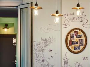 a wall with a drawing on the wall with lights at Greet Boulogne Billancourt Paris in Boulogne-Billancourt