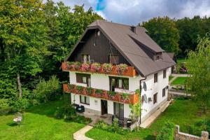 a house with a black roof and flower boxes at TOMLJANOVIĆ in Plitvička Jezera