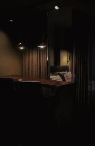 Stylish City Suite in the Heart of Jyväskylä في يوفاسكولا: غرفة مظلمة بها طاولة وكراسي ومرآة