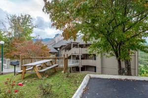 a park bench in the yard of a house at TeeTop Getaway by Avada Properties in Pittman Center