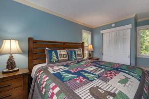 a bedroom with a bed with a christmas quilt at TeeTop Getaway by Avada Properties in Pittman Center
