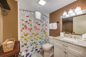 a bathroom with a shower curtain with a toilet and a sink at TeeTop Getaway by Avada Properties in Pittman Center +33 photos