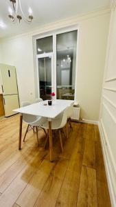 a dining room with a white table and chairs at Capital Park Flowers 5A in Astana