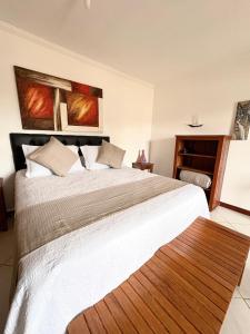 a bedroom with a large bed with white sheets at Pousada Banzay in Paraty +72 photos