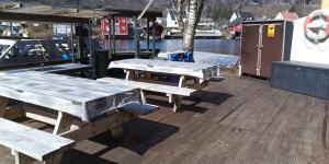a group of wooden picnic tables on a dock at ASFeriehus in Flekkefjord