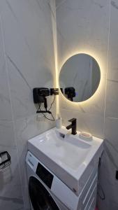 a bathroom with a white sink and a mirror at Апартаменты в ЖК Атамура in Karagandy