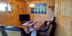 a living room with a table and chairs and a tv at ASFeriehus in Flekkefjord