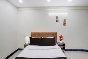 a bedroom with a large bed with black pillows at Hotel O Khammam Railway Junction Formerly Raghavendra Inn in Khammam
