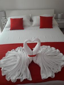 Dos cisnes blancos haciendo un corazón en una cama en Apartment Nina, en Split