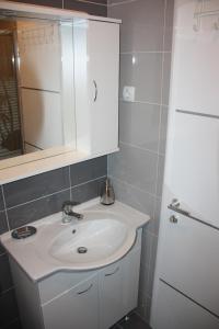 un bagno con un lavandino bianco e uno specchio di Apartment Nina a Spalato (Split)