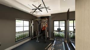 a gym with a treadmill and windows in a room at Aurelia Apartments in Mama