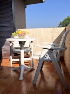 Una mesa y sillas en un patio con un bol de fruta. en Casa Poeti, en Nova Milanese