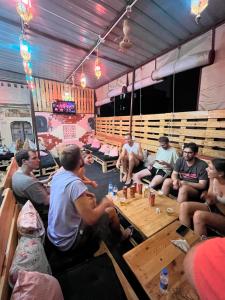 a group of people sitting around a table in a room at Pink City Backpackers in Jaipur