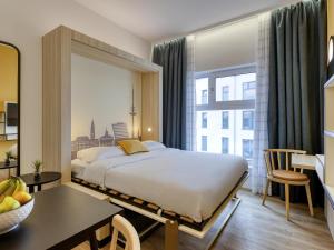 a hotel room with a bed and a table and a room at Aparthotel Adagio Access Kiel City in Kiel +43 photos