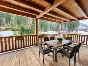 eine Holzterrasse mit einem Tisch und Stühlen darauf in der Unterkunft Hamatli Paznaun in Kappl