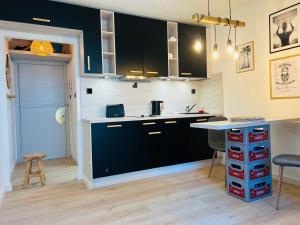 a kitchen with black and white cabinets and a table at MEERBLICKBUTZE by BUTZENFLOTTE Grömitz - Sitzfenster & Meerblick in Grömitz