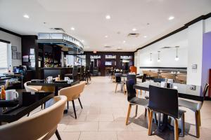 a restaurant with tables and chairs and a bar at Holiday Inn San Antonio North Stone Oak Area by IHG-Newly Renovated in San Antonio