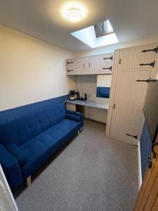 a blue couch in a room with a kitchen at Chew Valley Retreat Suite in Bishop Sutton