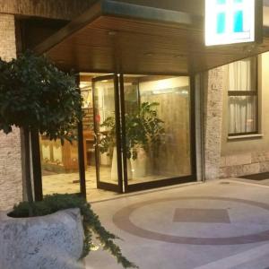 a building with a tree in front of a building at Hotel Excelsior in Lanciano