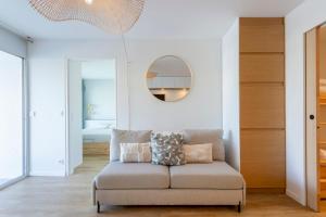 a living room with a couch and a mirror at La Loggia du Triton - Superbe T2 avec parking in Le Grau-du-Roi
