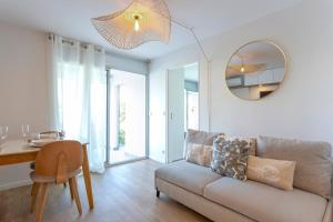 a living room with a couch and a table and a mirror at La Loggia du Triton - Superbe T2 avec parking in Le Grau-du-Roi +14 photos