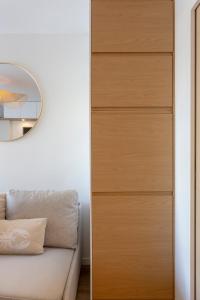 a room with a chest of drawers next to a couch at La Loggia du Triton - Superbe T2 avec parking in Le Grau-du-Roi
