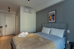 a bedroom with a bed with two towels on it at Bauhaus Vista 360° - Piscina Rooftop in Sao Paulo