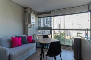 a living room with a couch and a table with pink pillows at Bauhaus Vista 360° - Piscina Rooftop in Sao Paulo
