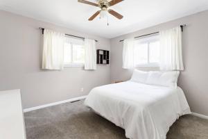 a bedroom with a white bed with a ceiling fan at 4Bedroom 2 Bath Home in Arts District-Smoky Row A in Carmel