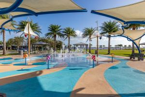 una piscina con una fuente en un parque con palmeras en Sherwin Condominium 1702, en Daytona Beach Shores