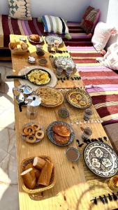 a wooden table with plates of food on it at Wild Surf Morocco in Agadir