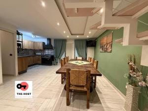 a dining room with a table and a kitchen at Large apartment with garden and cinema room in Giussano