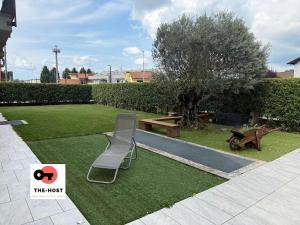 a park with a bench and a table and a tree at Large apartment with garden and cinema room in Giussano