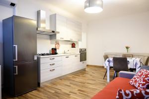 a kitchen with a refrigerator and a table in a room at Elegante appartamento in Centro storico - Vista sul corso principale - Spazioso , WiFi veloce, posizione top in Pordenone