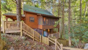 eine Blockhütte im Wald mit einer großen Terrasse in der Unterkunft Lakeside Cabin w Hot Tub Fireplace Near Dollywood Trails Smoky Shores Retreat by AvantStay in Little Cove