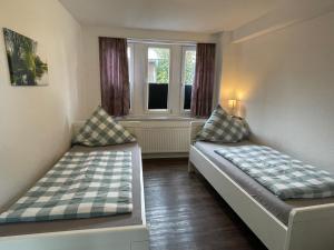 two beds sitting in a room with a window at Landhaus Zur Eiche in Sittensen