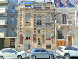 three cars parked in front of a building at Flor de Lino Hotel Porteño in Buenos Aires