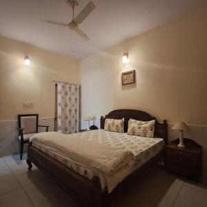Un dormitorio con una cama y un ventilador de techo. en Virasat Holiday Home 5Bedroom Villa, en Jodhpur